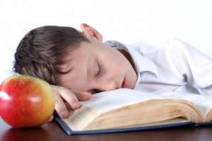 child sleeping on book 