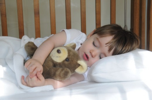 child sleeping with teddy bear